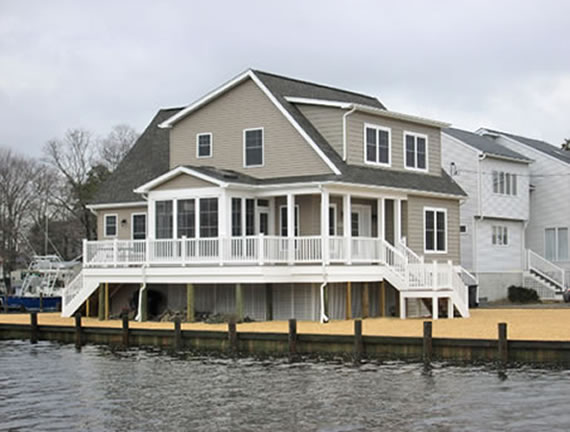 Custom designed cape style modular home takes advantage of lagoon water view from its deck and sun room on side of house.